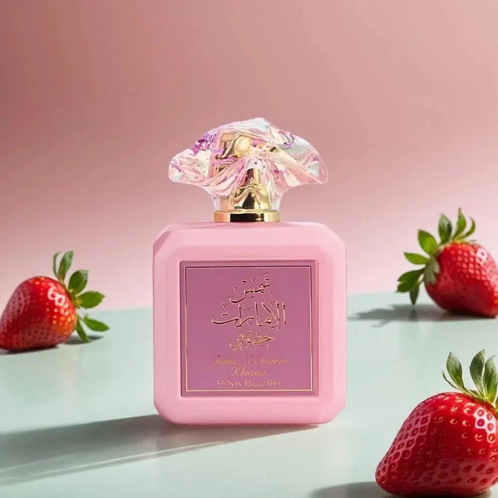 Bilde av parfymeflasken sammen med jordbær av Pink Blush Shams Al Emarat Khususi Perfume 100ml EDP by Ard Al Zaafaran
